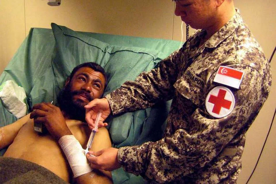Seorang anggota pasukan perubatan Angkatan Bersenjata Singapura (SAF) memberi rawatan di Afghanistan pada 2009. 