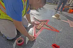 ROSAK EKORAN DIKAPAK: Seorang pekerja sedang memperbaiki 'bintang' Encik Trump di Hollywood Walk of Fame yang telah dirosakkan seorang lelaki. - Foto AFP