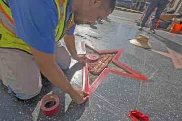 ROSAK EKORAN DIKAPAK: Seorang pekerja sedang memperbaiki 'bintang' Encik Trump di Hollywood Walk of Fame yang telah dirosakkan seorang lelaki. - Foto AFP