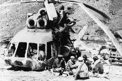 PERTAHAN NEGARA: Mujahidin Afghanistan makan tengah hari di sisi sebuah helikopter Soviet Union yang ditembak jatuh dalam satu serangan pejuang itu di Nuristan. Soviet Union melanggar Afghanistan pada 1979 tetapi menghadapi tentangan kuat dan berundur pada 15 Februari 1989. - Foto fail REUTERS