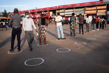 CEGAH VIRUS: Orang ramai berdiri dalam bulatan putih bagi mematuhi langkah jarak selamat bagi mengekang penularan koronavirus di stesen bas Nyabugogo, Kigali, Rwanda, pada 4 Mei lalu, hari pertama pemerintah melonggarkan perintah berkurung di negara itu. 