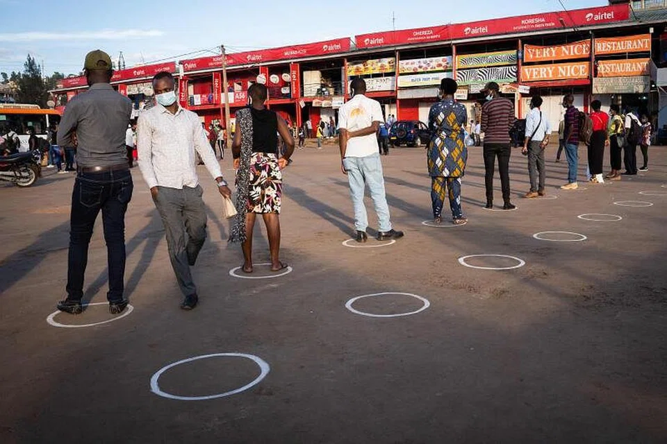 CEGAH VIRUS: Orang ramai berdiri dalam bulatan putih bagi mematuhi langkah jarak selamat bagi mengekang penularan koronavirus di stesen bas Nyabugogo, Kigali, Rwanda, pada 4 Mei lalu, hari pertama pemerintah melonggarkan perintah berkurung di negara itu. 