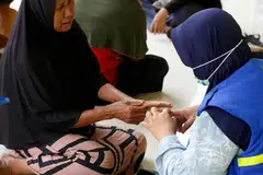 Sukarelawan kesihatan membantu penduduk dengan memberikan pemeriksaan kesihatan percuma di kawasan terjejas banjir di Kampung Babo, Aceh Tamiang, Aceh, Indonesia pada 6 Februari 2026. Pemerintah Indonesia menyatakan proses pemulihan pascabencana masih perlahan berikutan beberapa halangan seperti kerosakan infrastruktur jambatan dan kesukaran menentukan lokasi penempatan semula mangsa banjir.