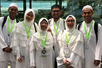 Cik Sumi Majuri (tiga dari kiri), penerima tokokan MediSave untuk Generasi Perintis pada Julai, kerap ditemani oleh anak perempuannya, Cik Jueita Jalil (dua dari kanan), dan menantunya Encik Noorhaizam Hatbi (tiga dari kanan), serta cucu-cucunya ke Hospital Besar Sengkang untuk menjalani pemeriksaan kesihatan. Gambar dirakam semasa mereka sekeluarga mengerjakan umrah pada 2019.