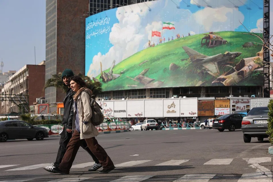 Orang ramai berjalan melepasi papan iklan anti-Amerika Syarikat di sebuah jalan di Teheran, Iran, pada 5 Februari 2026.