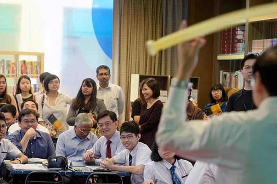 KELAS DEMONSTRASI FIZIK: Menteri Pendidikan, Encik Heng Swee Keat (duduk, dua dari kanan), menyertai kelas fizik bersama pelajar semasa pelancaran Pusat bagi Kecemerlangan Pengajaran & Pembelajaran. - Foto THE STRAITS TIMES