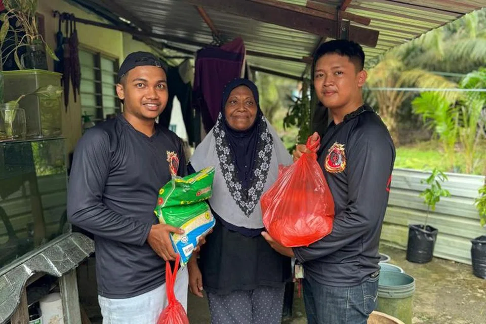 IKUT AYAH BUAT KERJA AMAL: Encik Muhd Raimy (kiri) mula mengekor ayahnya sejak kecil dan kini turut terlibat dalam kegiatan anjuran kumpulan Yoshiko.