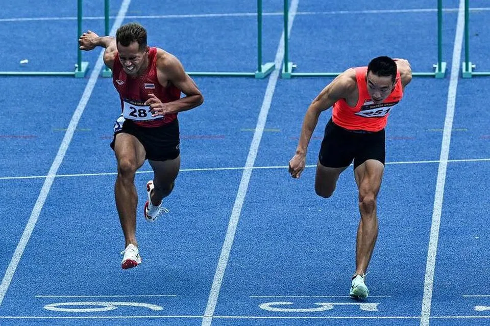 KONGSI EMAS: Atlet balapan negara Ang Chen Xiang (kanan) dan Natthaphon Dansungnoen dari Thailand berkongsi emas dalam acara balapan 110 meter lelaki. - Foto ST. 