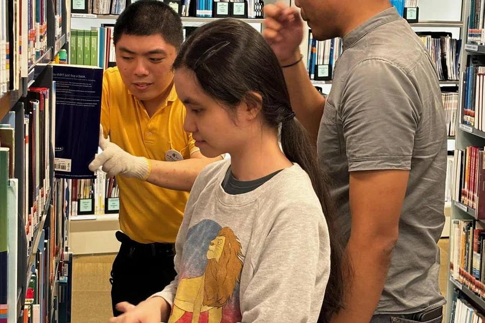Cik Yeo Hui Qing dan Encik K. R. Teh ditempatkan di Perpustakaan Rujukan Lee Kong Chian sebagai pembantu perkhidmatan perpustakaan. Encik Muhammad Iqbal Buang (kanan), sebagai ketua pasukan, sedang menyelia kerja mereka.