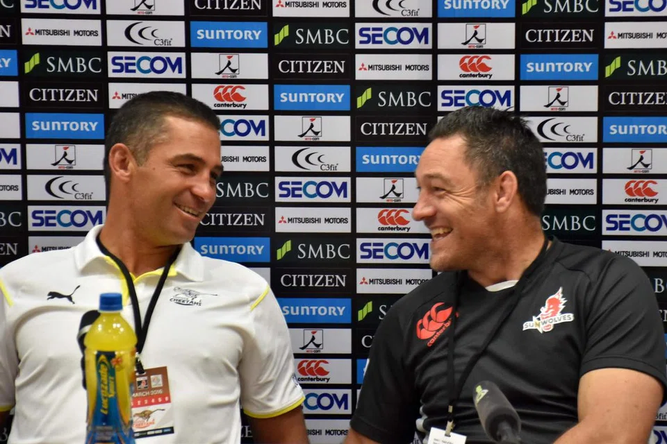 BERSELOROH SEBELUM BERTEMPUR: Jurulatih Sunwolves, Mark Hammett (kanan), berkongsi detik lucu dengan rakan sejawatannya daripada pasukan Cheetahs, Franco Smith, di sidang media semalam. Kededua pasukan itu akan berentap dalam siri Super Rugby di Stadium Negara petang ini. - Foto AFP