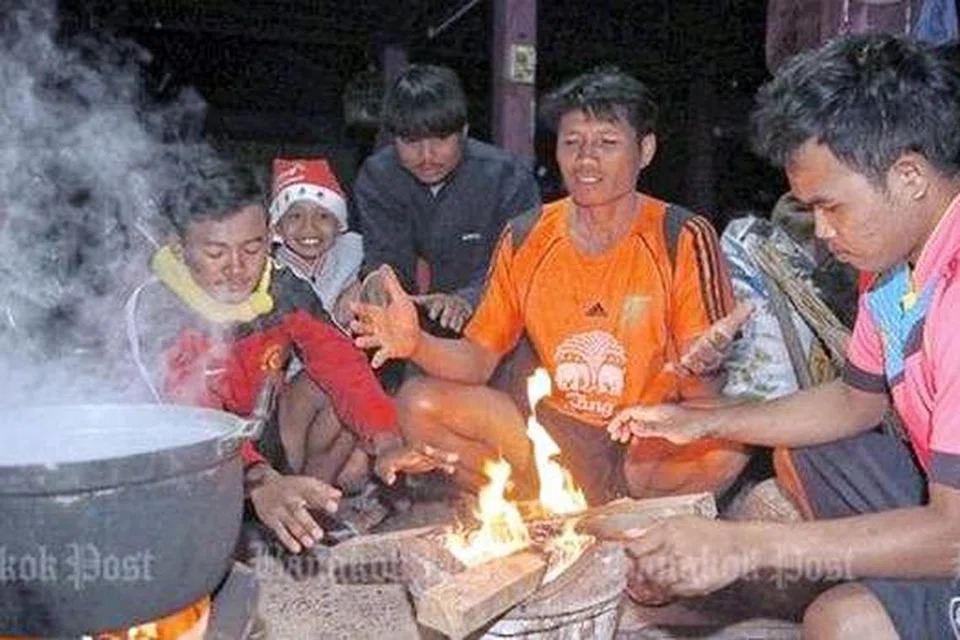 PANASKAN BADAN: Api merupakan satu-satu cara untuk memanaskan badan bagi ramai penduduk di utara dan timur laut Thailand yang kini dilanda cuaca sejuk. - Foto BANGKOK POST