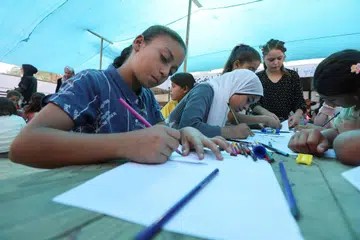 Kanak-kanak mewarna lukisan dalam satu aktiviti sokongan psikologi anjuran Persatuan Bulan Sabit Merah Palestin, di Khan Younis, selatan Jaluran Gaza, 28 Oktober 2025.