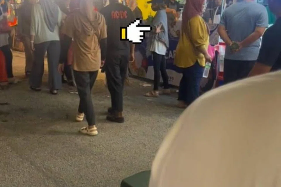 DIDERA TEMAN LELAKI: Mangsa membuat ‘Isyarat untuk Bantuan’ berkali-kali untuk mendapat perhatian dan pertolongan daripada orang sekeliling di karnival Petaling Jaya, Malaysia.