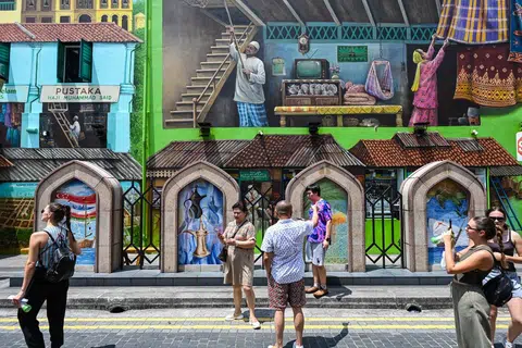 Mural oleh Yip Yew Chong di latar belakang menggambarkan suasana Kampong Gelam pada zaman dahulu. Di sebelahnya, lukisan dinding bertema budaya Oman seperti kapal layar dan pokok kurma memperlihatkan sejarah perdagangan di kawasan Muscat Street.