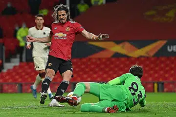 BERBISA: Penyerang Manchester United, Edinson Cavani (kiri) menewaskan penjaga gol Roma Antonio Mirante untuk gol ketiga mereka pada aksi separuh akhir pertama Liga Europa di Old Trafford. - Foto AFP