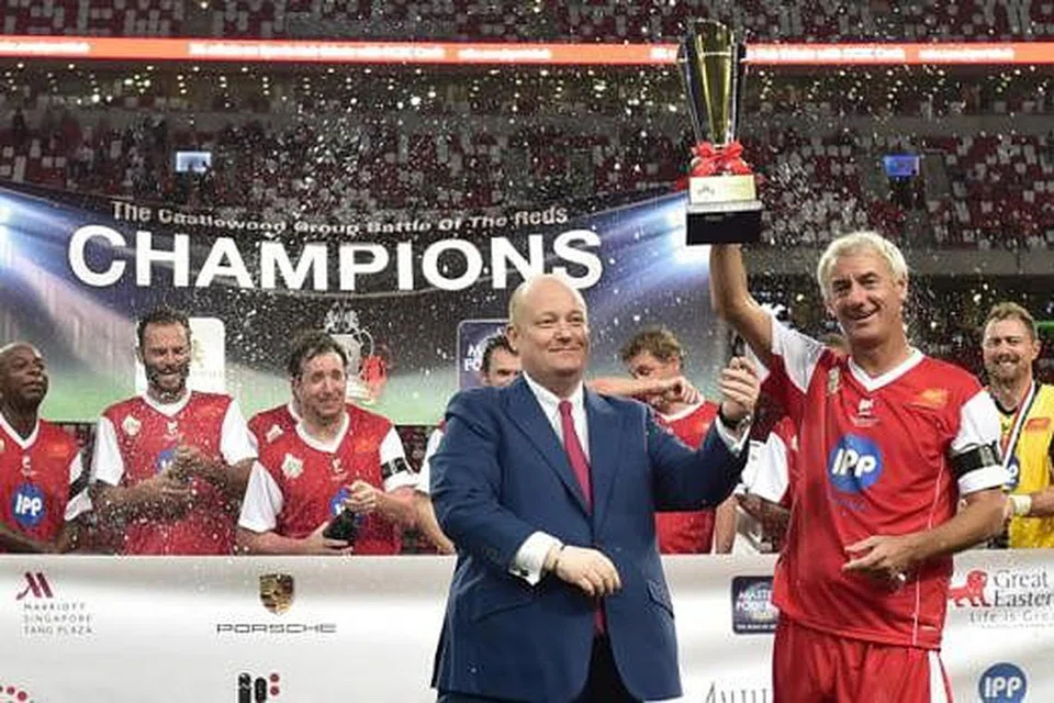JUARA: Kapten Liverpool Masters, Ian Rush (jersi merah), menjulang trofi kejuaraan selepas kejayaan menewaskan Manchester United Master di Stadium Negara malam kelmarin. - Foto MASTERS FOOTBALL ASIA
