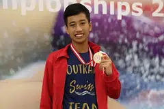 KEBANGGAAN SEKOLAH: Ardi Zulhilmi Mohamed Azman menghadiahkan pingat emas kepada Sekolah Menengah Outram di Kejohanan Antara Sekolah-Sekolah Nasional Divisyen 'B' yang berlangsung di Pusat Akuatik OCBC semalam. - Foto ZARINA MOHD RAZALI