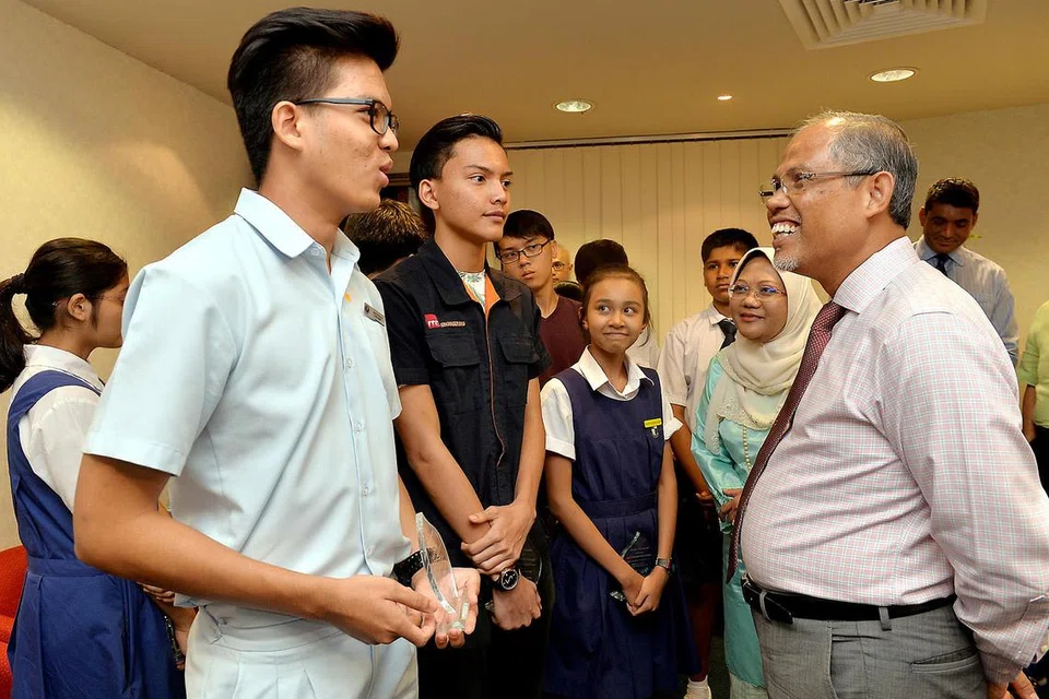 KECEMERLANGAN DIIKTIRAF: Encik Masagos (kanan) dan Ketua Pegawai Operasi Mendaki, Cik Zulaiha Yusuf (bertudung), beramah mesra dengan penerima Anugerah Pelajar Terbaik Secara Keseluruhan Akademik bagi (dari kiri) GCE peringkat 'O', Adam Norazhar; peringkat 'N', Muhammad Izzul Isam Jamil dan PSLE, Imanina Mohamed Zalaini. - Foto M.O. SALLEH