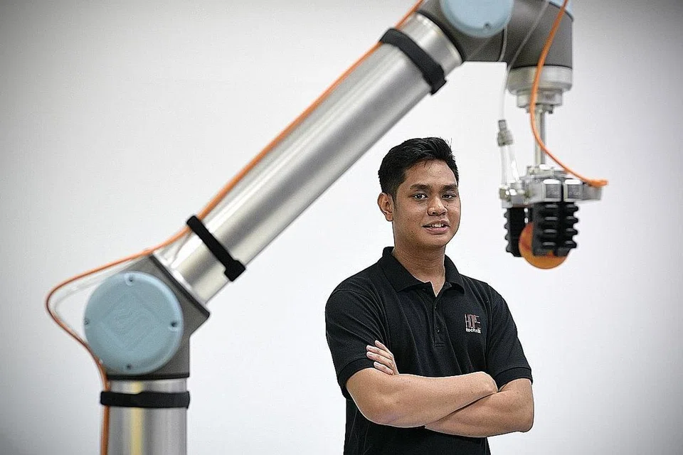 SUKA ROBOTIK: Setelah menanam minat dalam robotik sejak di bangku sekolah lagi, akhirnya hajat Encik Muhammad Asraf tercapai jua untuk menjadi karyawan dalam bidang itu, hasil penyertaan dalam program pelatih kendalian SG Innovate. - Foto BH oleh NG SOR LUAN