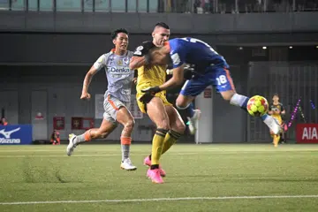 TERKAMAN KAD MERAH: Penjaga gawang Albirex Niigata, Hassan Sunny (jersi biru), cuba selamatkan keadaan daripada serangan pemain Tampines Rovers, Boris Kopitovic. Beliau diperintah keluar padang sejurus sebelum rehat dalam perlawanan di Our Tampines Hub (OTH) pada Selasa.