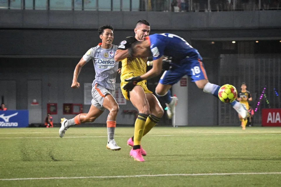 TERKAMAN KAD MERAH: Penjaga gawang Albirex Niigata, Hassan Sunny (jersi biru), cuba selamatkan keadaan daripada serangan pemain Tampines Rovers, Boris Kopitovic. Beliau diperintah keluar padang sejurus sebelum rehat dalam perlawanan di Our Tampines Hub (OTH) pada Selasa.