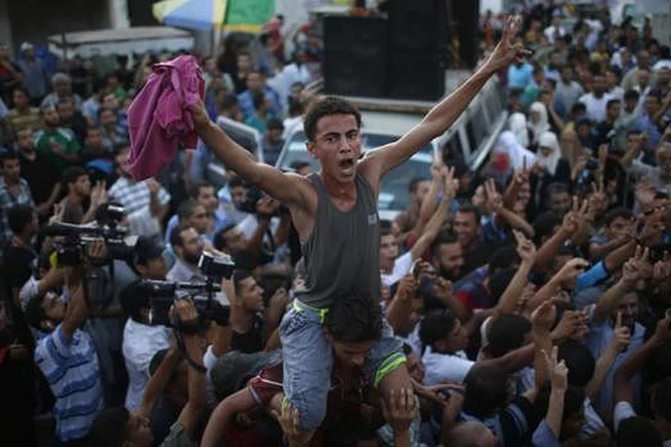 RAIKAN GENCATAN: Penduduk Gaza semalam meraikan gencatan senjata usulan Mesir yang dimeterai dengan Israel. - Foto REUTERS