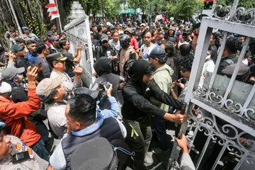 Penunjuk perasaan cuba menutup pintu untuk menghalang ahli parlimen keluar ketika mereka membantah menuntut peletakan jawatan Presiden Indonesia Joko Widodo, sehari sebelum lawatan rasminya ke Yogyakarta, di Parlimen di Yogyakarta, pada 27 Ogos. 