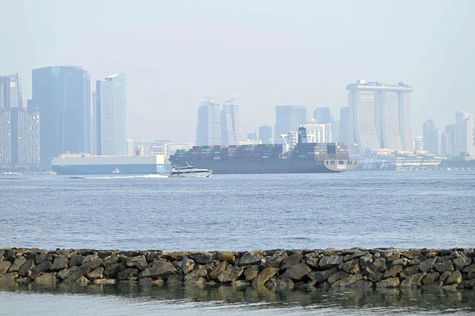 DISELUBUNGI KABUT: Keadaan persekitaran pusat bandar Singapura yang tidak begitu jelas tatkala bot dan kapal melalui Selat Singapura disebabkan jerebu.