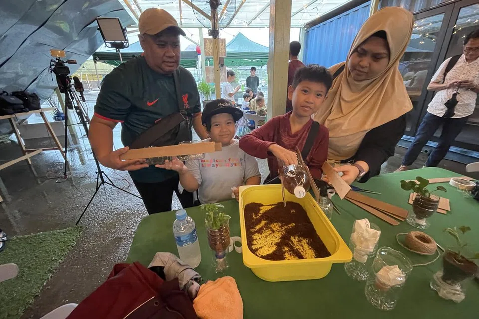 BERKEBUN SECARA MAMPAN: Encik Shahrin Mashoed, bersama  dua anaknya Arissa Zahrah dan Ariz Ilhan, serta isteri, Cik Siti Yusoff (kanan), menyertai bengkel di mana mereka belajar cara membuat alat penanam siraman kendiri (self-watering planter) serta penanam yang dibuat dengan bahan yang boleh dikitar semula. 