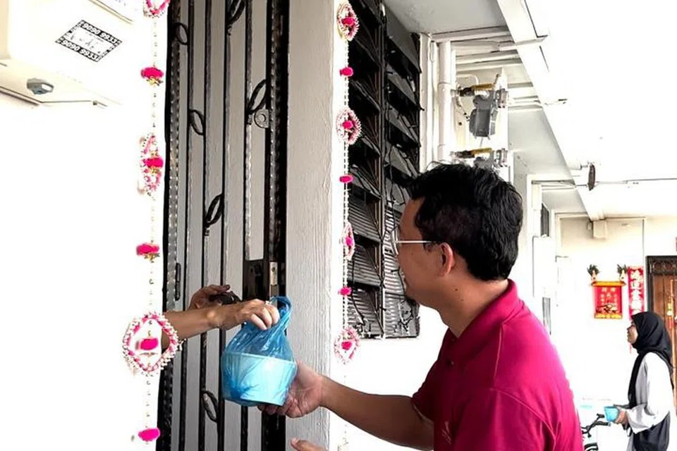 Ahli Lembaga Pentadbiran Masjid (LPM) Alkaff Kampung Melayu, Encik Ezril Jamil, sedang memberikan bubur masjid kepada salah seorang penduduk di Bedok Reservoir. 