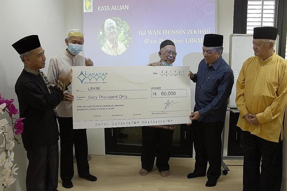 SUMBANGAN UNTUK KEMPEN MAULID LBKM: Seramai 160 pelajar dewasa dari kelas tafsir Al-Amanah bimbingan Ustaz Muhammad Zuhal Abdul Lathif, menyumbang $60,000 dalam satu usaha mengumpul dana sempena Kempen Maulid LBKM. Ustaz Muhammad Zuhal (kiri) telah memberikan cek sumbangan dana itu kepada Presiden LBKM, Encik Suhaimi Salleh (berbaju biru) dan Mantan Presiden LBKM, Encik Wan Hussin Zoohri (baju kuning) pada Ahad lalu di Ilm Centre, Joo Chiat Road. - Foto LBKM
