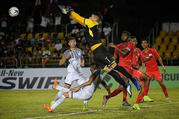 SELAMATKAN KEADAAN: Penjaga gawang Filipina, Neil Etheridge, menumbuk bola bagi menyelamatkan keadaan menyusuli tendangan sudut yang gagal dimanfaatkan pasukan Singapura. - Foto BH oleh MARK CHEONG