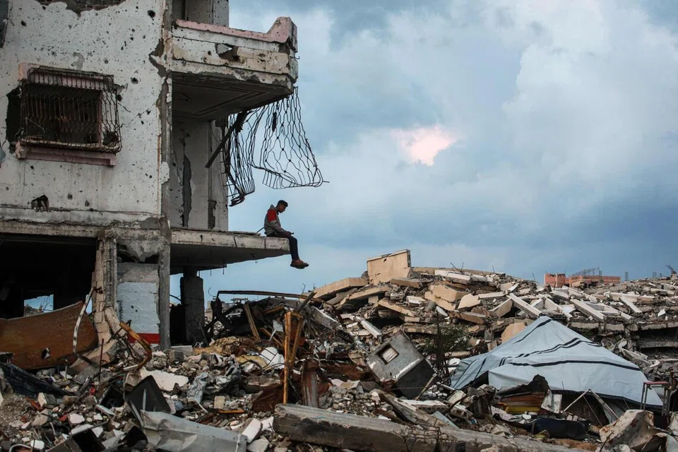 Seorang lelaki duduk di hujung sebuah bangunan yang musnah di kawasan kejiranan Al-Saftawi, di sebelah barat bandar Jabalia di utara Jaluran Gaza pada 10 Disember. 