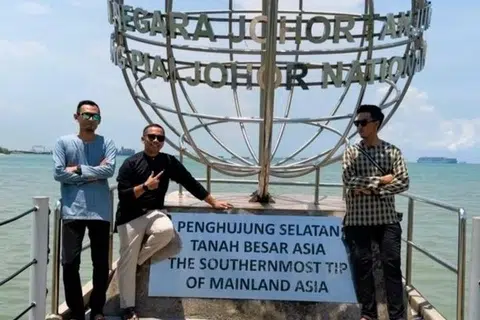 Encik Ezzri Norhisham Zainuding (dua dari kiri) bersama dua rakan sekerjanya bergambar di Dataran Globe Penghujung Selatan Benua Asia.