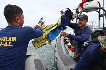 USAHA MENCARI: Penyelam tentera laut memindahkan serpihan pesawat Sriwijaya Air Boeing 737-500 semasa operasi mencari berhampiran Pulau Lancang pada 10 Januari 2021. Pesawat malang itu terhempas ke Laut Jawa beberapa minit selepas berlepas dari lapangan terbang Soekarno-Hatta di Jakarta. - Foto AFP