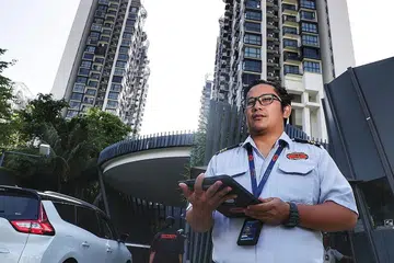 LEBIH BERKESAN: Tugas penyelia keselamatan, Encik Mohammed Alfie Idris, kini lebih mudah dan pantas selepas majikannya, Metropolis Security Systems, mula menggunakan teknologi yang dapat mengesan plat nombor kenderaan, dengan maklumat itu kemudian akan dirakamkan dalam satu sistem perawanan dalam iPad secara automatik. - Foto BM oleh KELVIN CHNG