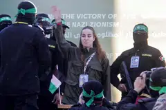 Anggota tentera wanita Israel, Cik Agam Berger, melambai kepada orang ramai ketika beliau dibebaskan oleh militan Hamas Palestin. 