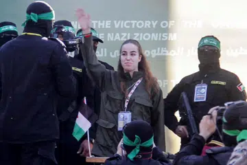 Anggota tentera wanita Israel, Cik Agam Berger, melambai kepada orang ramai ketika beliau dibebaskan oleh militan Hamas Palestin. 