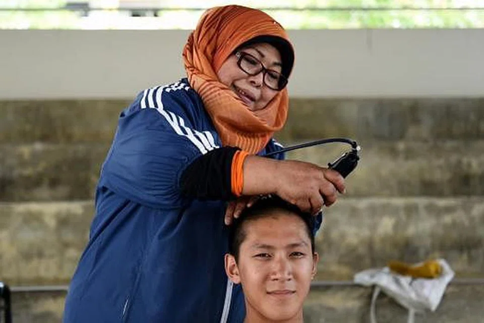 GUNTING RAMBUT DI TEKONG: Cik Rose mengambil masa sekitar 45 saat hingga seminit untuk memotong rambut rekrut di Pulau Tekong. - Foto MINDEF