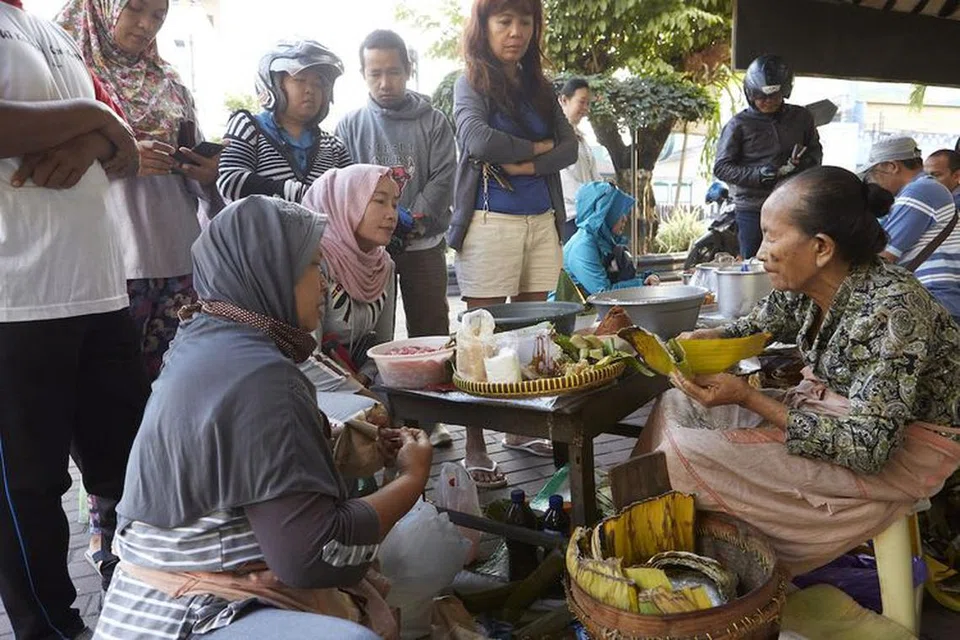 JAJAN PASAR: Di Yogyakarta, makanan jalanan tradisional dipanggil ‘jajan pasar’ yang menjual beraneka kuih-muih. Penjualnya (kiri) Mbah Satinem dalam lingkungan 70-an tahun masih menjual jajan pasar bersama keluarganya.