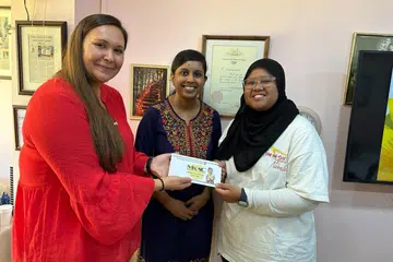 USAHA MURNI: (Dari kiri) Dr Jamie Cahoon dari Montana, Amerika Syarikat dan Dr Sheena Ramazanu mendermakan $3,000 pada 2023 untuk memberikan Anugerah Shine Bright MKAC kepada 12 pelajar daripada keluarga kurang kemampuan.  Bersama mereka ialah seorang penerima anugerah, Cik Nur Ain Mohamad Puzi, pelajar tahun kedua jurusan Kejuruteraan Elektrik dari Politeknik Ngee Ann.