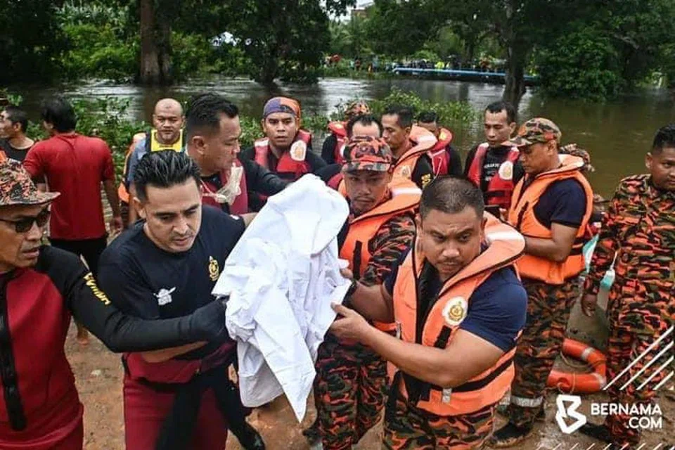 KORBAN BANJIR: Anggota bomba mengangkat mayat korban banjir pertama di Terengganu, Allahyarham Muhamad Harraz Ilman Mohd Syahril Redhuan, 11 tahun, yang ditemui lemas pada 11 pagi, 28 Disember, di dasar Sungai Tok Hakim, Kampung Tok Hakim, Padang Midin, Kuala Terenganu, Terengganu.