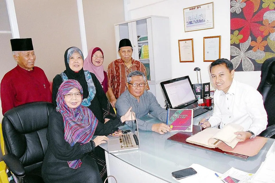 REDAKSI BUKU 'MASYARAKAT BAWEAN SINGAPURA LA-A-OBE': (Duduk dari kiri) Cik Sundusia, Haji Asmawi Majid dan Haji Faizal serta (berdiri dari kiri) Haji Mohd Seain, Cik Rohanah Pagi, Cik Nurul Sa'adah Mohammad Seain dan Haji Morni Sulaiman. - Foto SAINI SALLEH