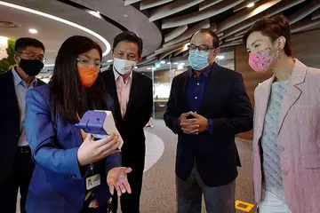 DIBERI TAKLIMAT: (Dari kanan) Cik Josephine Teo, Encik S. Iswaran dan Encik Chan Chun Sing diberi taklimat semasa lawatan mereka ke Becton Dickinson Asia Pasifik semalam. - Foto BH oleh NG SOR LUAN