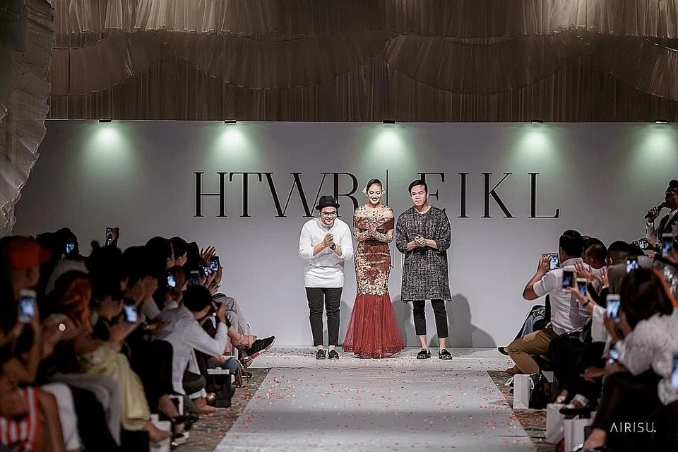 PERTUNJUKAN FESYEN PERTAMA: Pengasas butik andaman setempat Hambali The Wedding Regalia, Encik Mohammad Hambali (kiri), bergabung dengan pereka fesyen terkenal dari Kuala Lumpur, Encik Ezuwan Ismail (kanan), bagi menghasilkan busana pengantin terbaru dan mempersembah koleksi tersebut di pertunjukan fesyen One. Di tengah ialah model pakaian pengantin yang mengenakan songket.