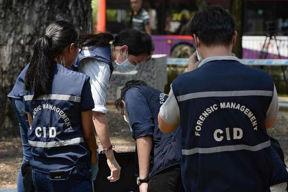 Pegawai polis, termasuk daripada Jabatan Siasatan Jenayah (CID), menyiasat di sebuah tempat kejadian jenayah, 