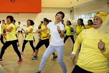 BERSENAM SAMBIL BERINTERAKSI: Cik Grace Fu (berkemeja-T putih) menyertai penduduk melakukan senaman di Kelab Masyarakat Woodlands Galaxy. - Foto THE STRAITS TIMES