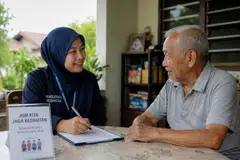 Penyelaras kesejahteraan (kiri) berbual bersama seorang warga emas semasa sesi lawatan masyarakat bagi membantu memantau keadaan kesihatan, kebajikan dan keperluan harian penduduk. Pendekatan secara peribadi dan mesra membantu membina kepercayaan serta memastikan warga emas terus mendapat sokongan yang diperlukan dalam masyarakat.