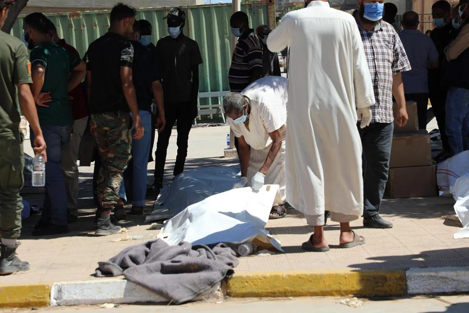 KEBUMI JENAZAH: Para pekerja membuat persiapan bagi membawa mayat yang dijumpai terapung di laut pada Rabu ke hospital di Derna, Libya.