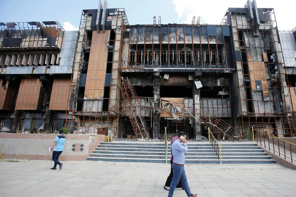 PERJUANGAN PELAJAR: Raghad Hammoudi di bangunan Perpustakaan Pusat Universiti Mosul yang musnah akibat pertempuran menentang militan ISIS. Beliau dan rakan-rakan pelajarnya sedang berjuang memulihkan perpustakaan itu (gambar atas). - Foto REUTERS